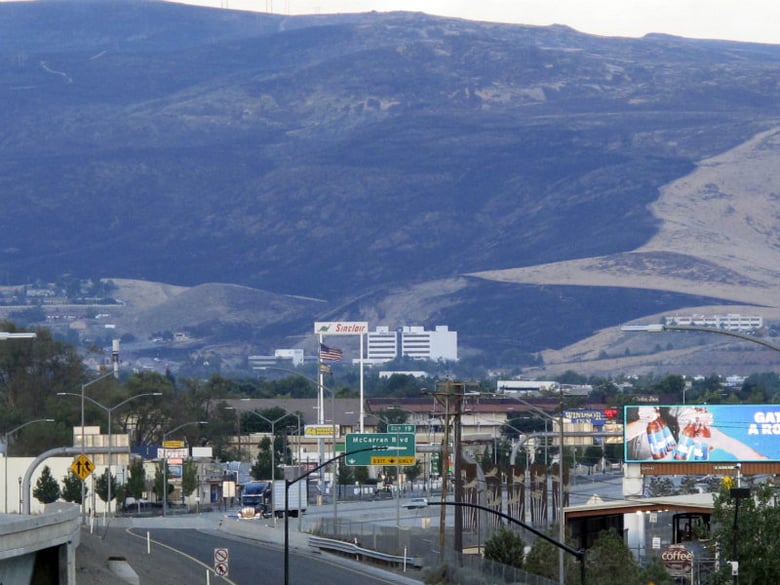 Traffic passes Sunday evening, Aug. 6, 2017 on U.S. Interstate 80 in Sparks, Nevada, after voluntary evacuation orders were lifted due to a wildfire that threatened nearly two dozen homes. 